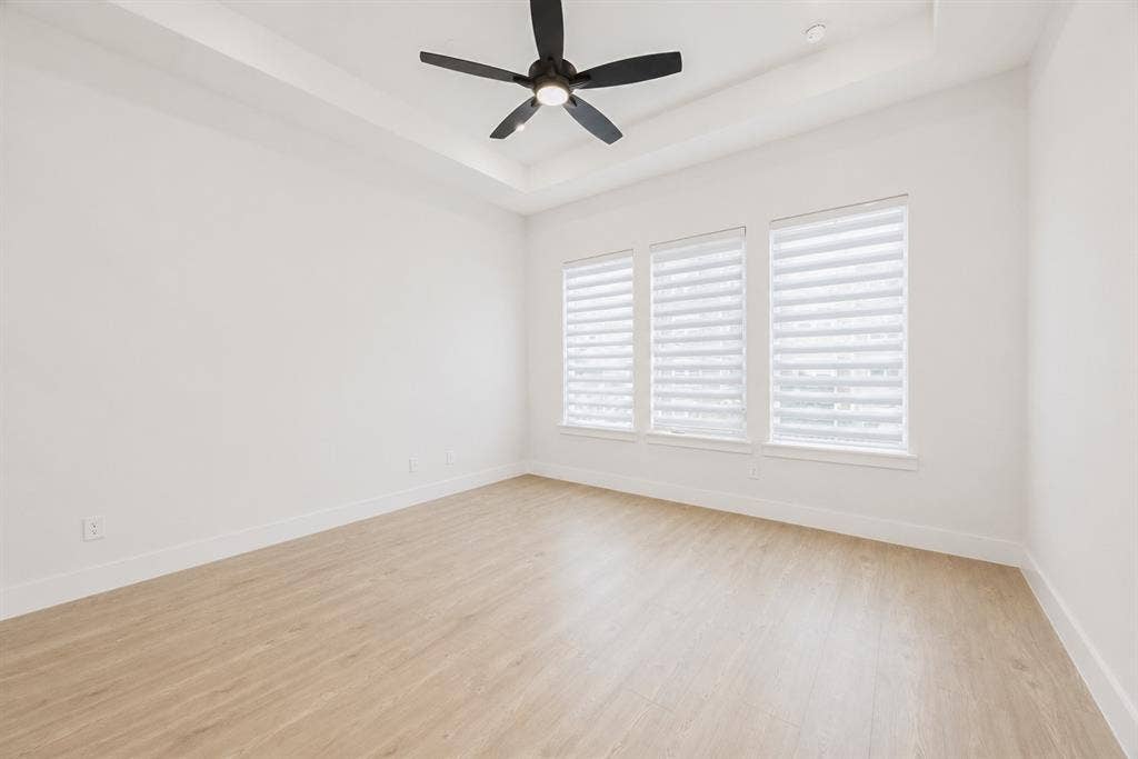 11965 Brubaker Drive, Frisco, TX 75033 Spacious room featuring wood-finish flooring, a tray ceiling, and a black ceiling fan with integrated lighting