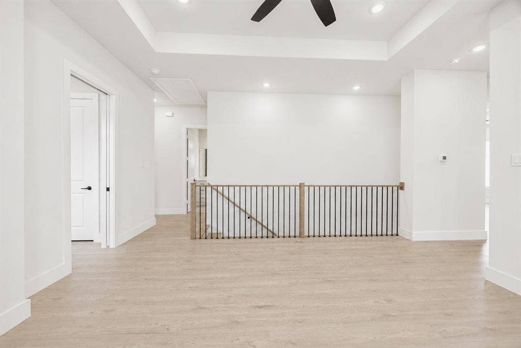 11965 Brubaker Drive, Frisco, TX 75033 Spacious open concept room featuring light wood-finish flooring, white walls, and a tray ceiling with recessed lighting