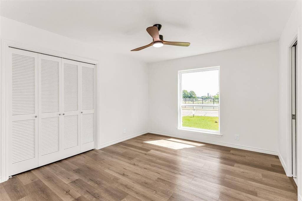101 Hollyhill Lane, Denton, TX 76205 Bright room featuring wood-finish flooring, a contemporary ceiling fan, and a wide window