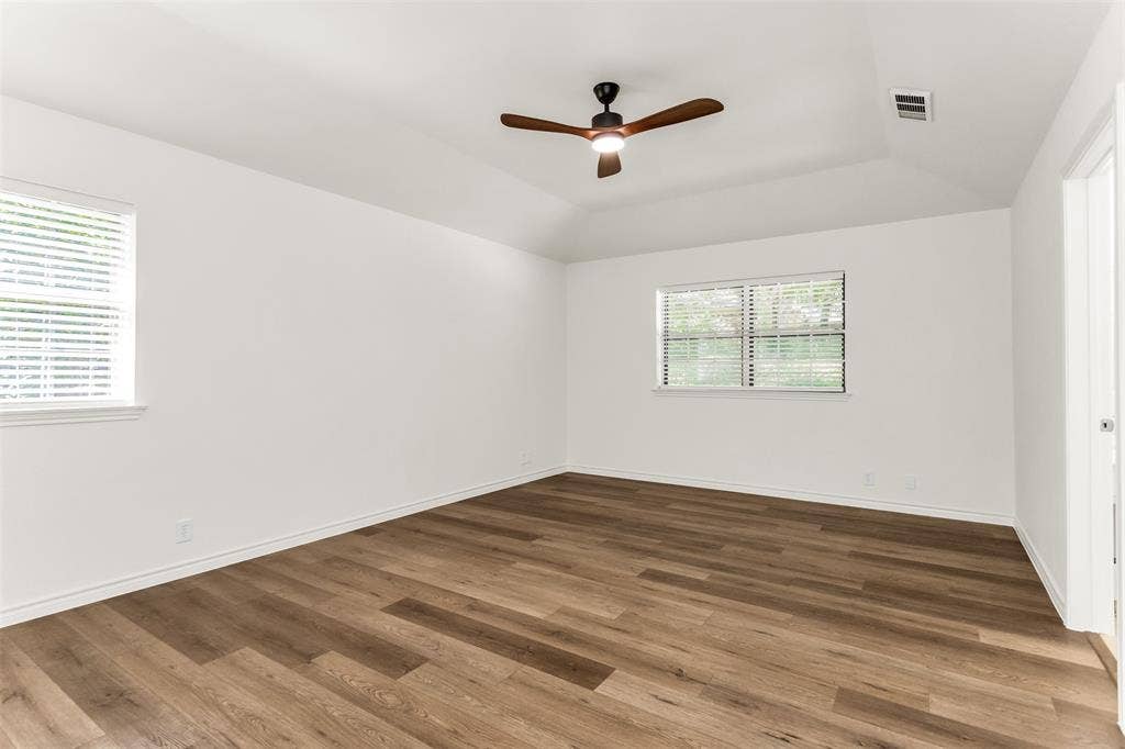 101 Hollyhill Lane, Denton, TX 76205 Spacious room featuring wood-finish flooring, vaulted ceilings, and a ceiling fan with integrated lighting