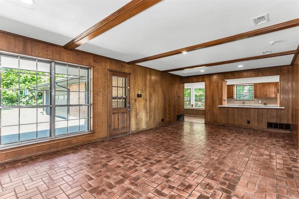 101 Hollyhill Lane, Denton, TX 76205 Interior living space featuring brick-patterned flooring, wood paneling, and exposed ceiling beams