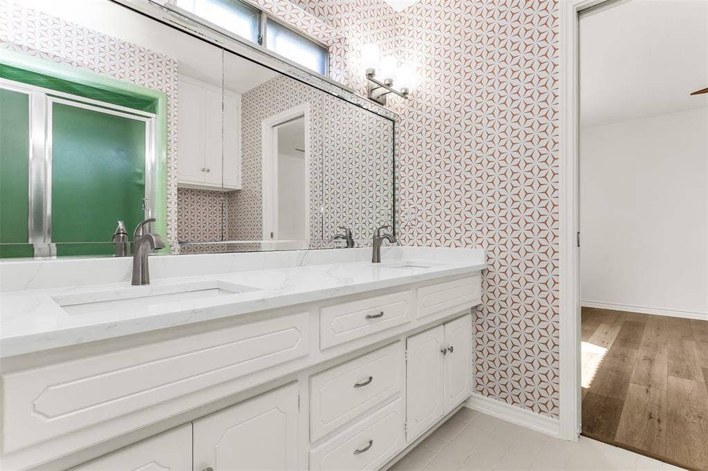 101 Hollyhill Lane, Denton, TX 76205 Dual vanity with a white countertop and integrated sinks, complemented by contemporary faucets and white cabinetry