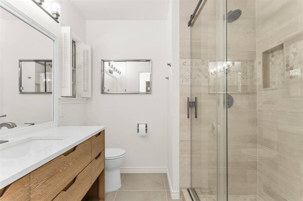 101 Hollyhill Lane, Denton, TX 76205 Modern bathroom featuring a wood-finish vanity with a white countertop and integrated sink