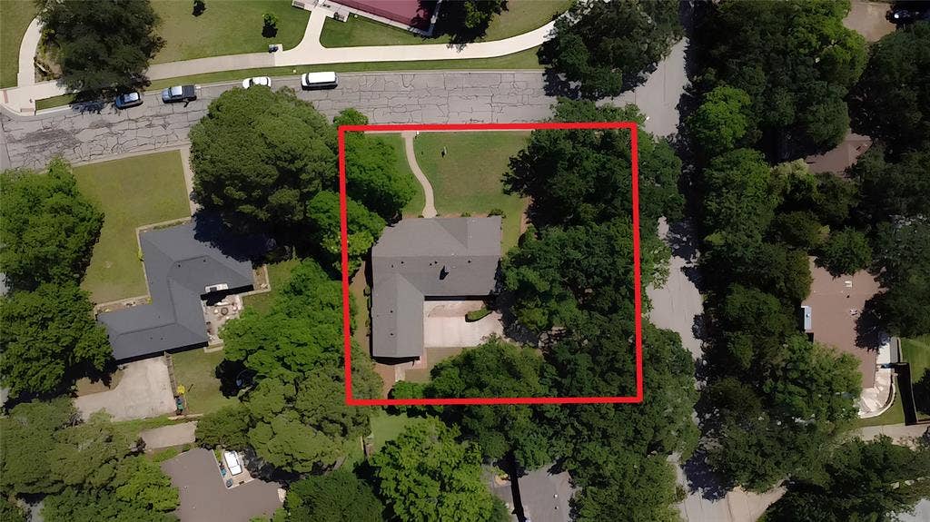 101 Hollyhill Lane, Denton, TX 76205 Aerial view of a residential property with a central house featuring a grey roofline and a paved driveway
