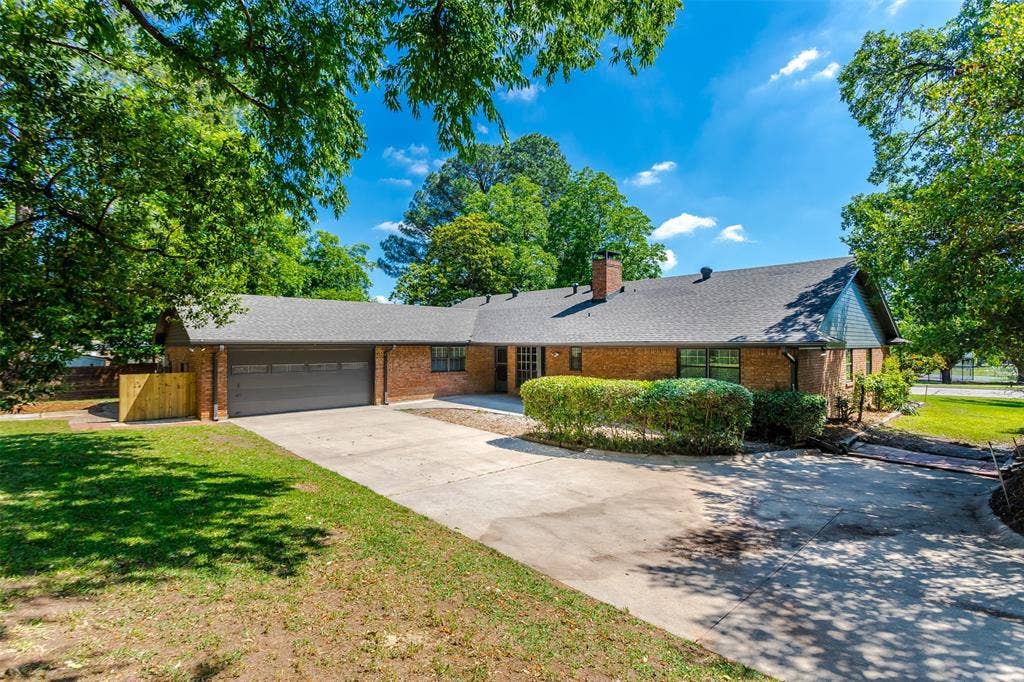 101 Hollyhill Lane, Denton, TX 76205 Brick exterior with a gray shingle roof and a two-car garage