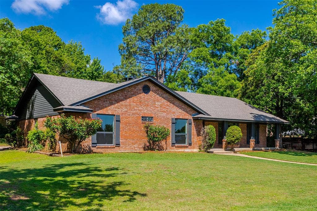 101 Hollyhill Lane, Denton, TX 76205 Brick exterior with a gabled roof and dark siding accents