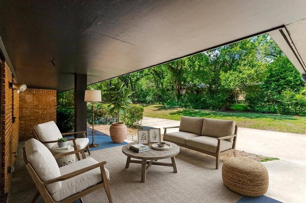 101 Hollyhill Lane, Denton, TX 76205 Covered patio featuring a dark overhead soffit, brick wall, and concrete flooring