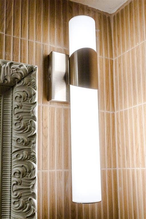 101 Hollyhill Lane, Denton, TX 76205 Vertical wall sconce with a brushed metal accent, featuring a frosted glass diffuser