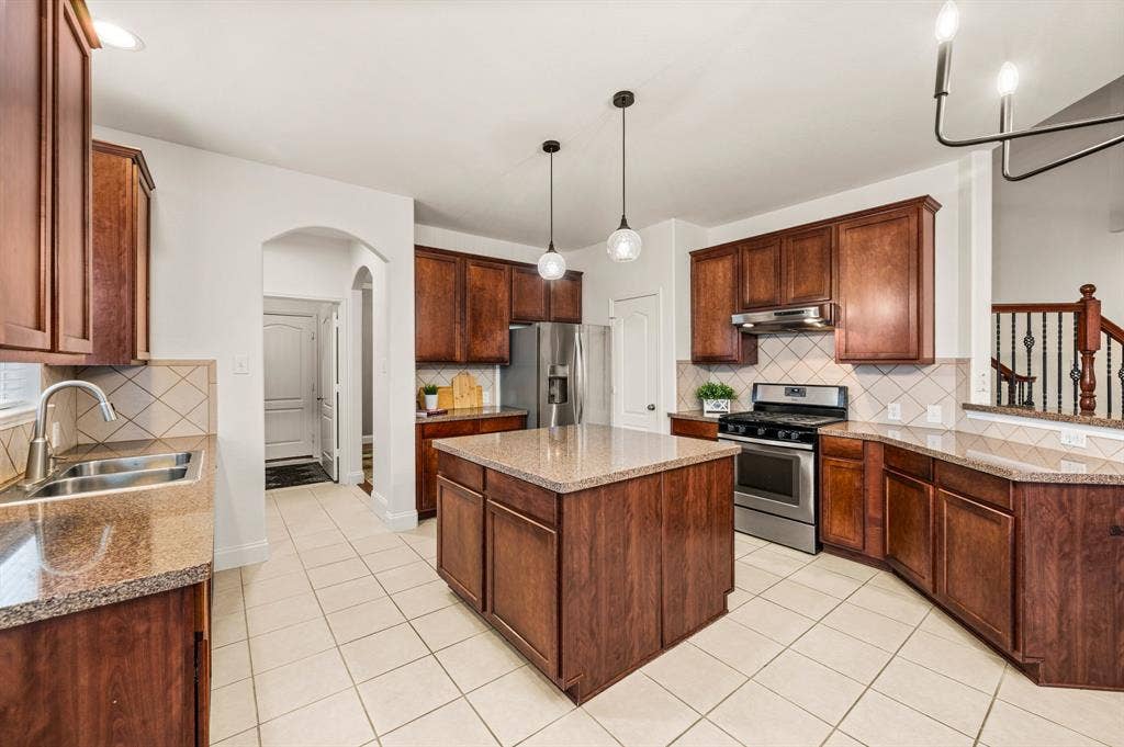308 Bradbury Drive, Euless, TX 76040 Bright & functional kitchen with stainless steel refrigerator, center island & walk-in pantry access.