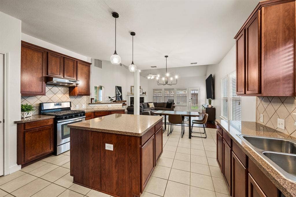 308 Bradbury Drive, Euless, TX 76040 Open-concept kitchen featuring a large center island, gas cooking & seamless flow into the living area.