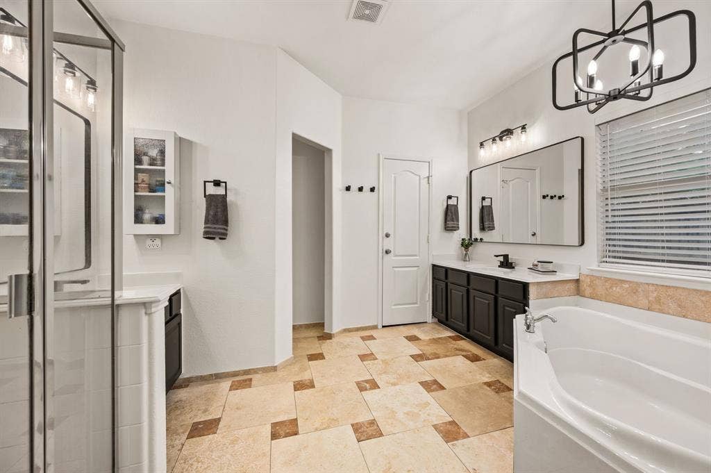 308 Bradbury Drive, Euless, TX 76040 Luxurious primary bath featuring dual vanities, soaking tub & oversized walk-in shower.