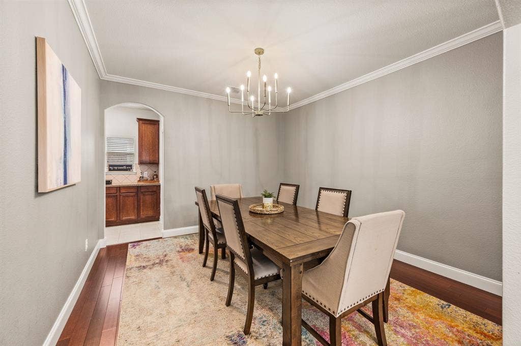 308 Bradbury Drive, Euless, TX 76040 Formal dining room with crown molding & designer lighting ready for memorable gatherings.