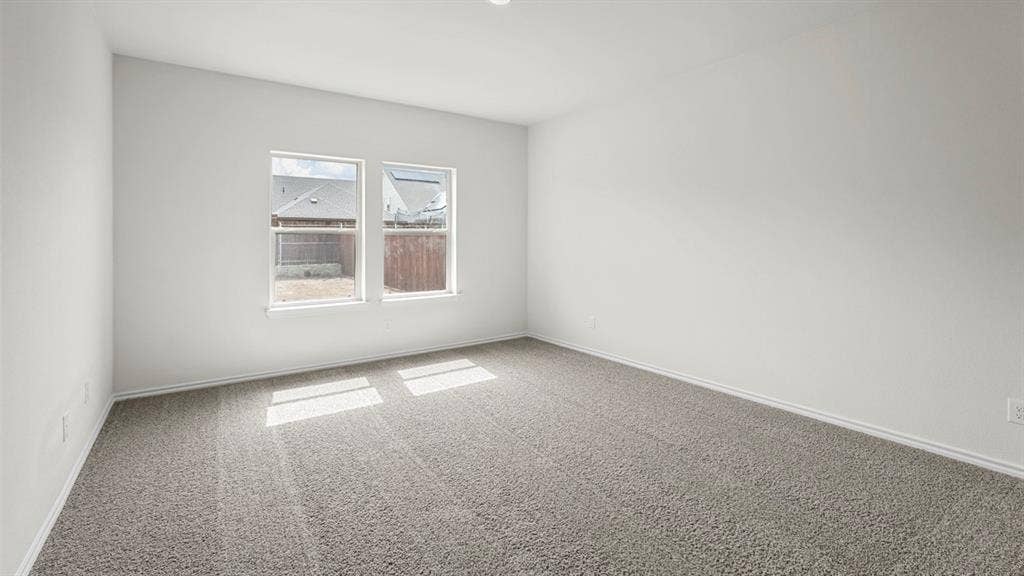 1619 Blaire Drive, Tyler, TX 75702 Carpeted room featuring two windows and white baseboards
