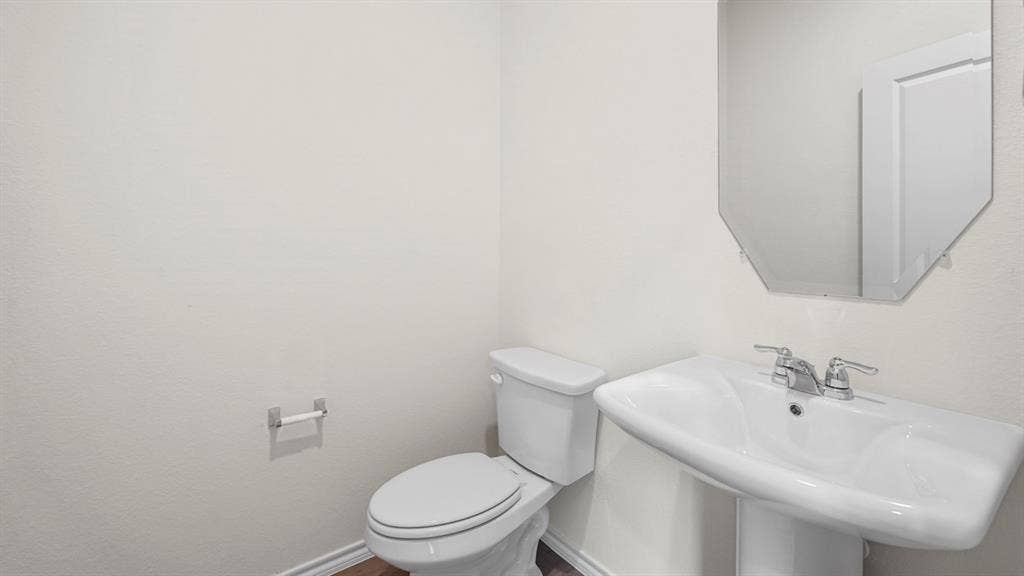 1619 Blaire Drive, Tyler, TX 75702 Pedestal sink with chrome fixtures and an octagonal mirror