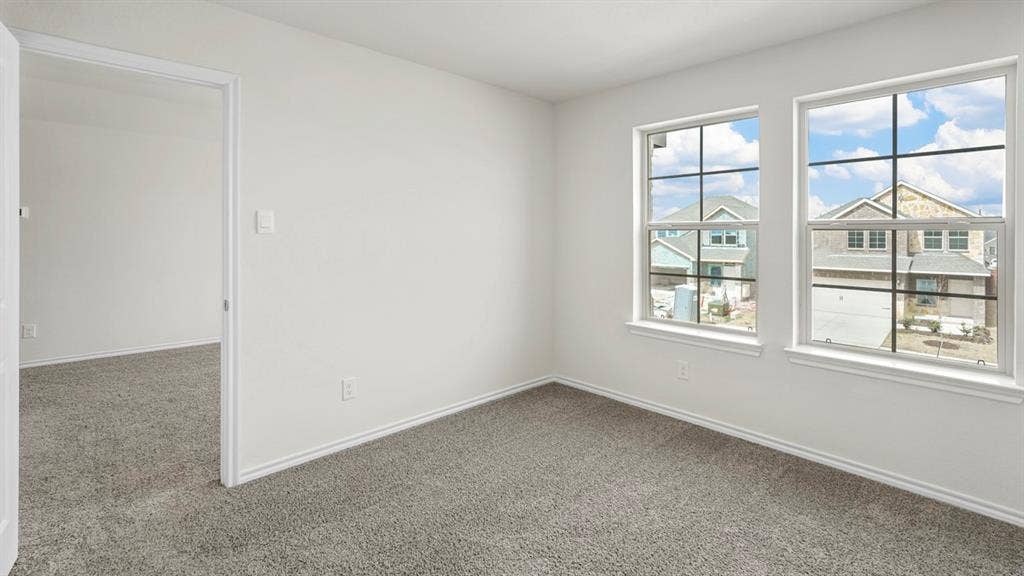 1619 Blaire Drive, Tyler, TX 75702 Room with gray carpeting, white walls, and two large windows featuring grid patterns