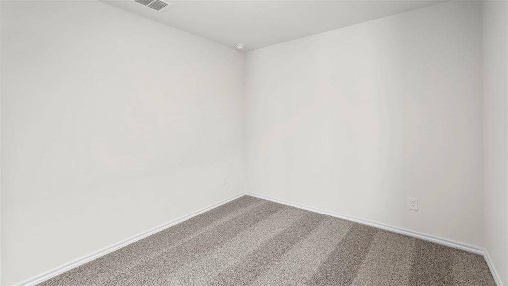 1619 Blaire Drive, Tyler, TX 75702 Light gray carpet flooring with visible vacuum lines, complemented by white baseboards and neutral white walls