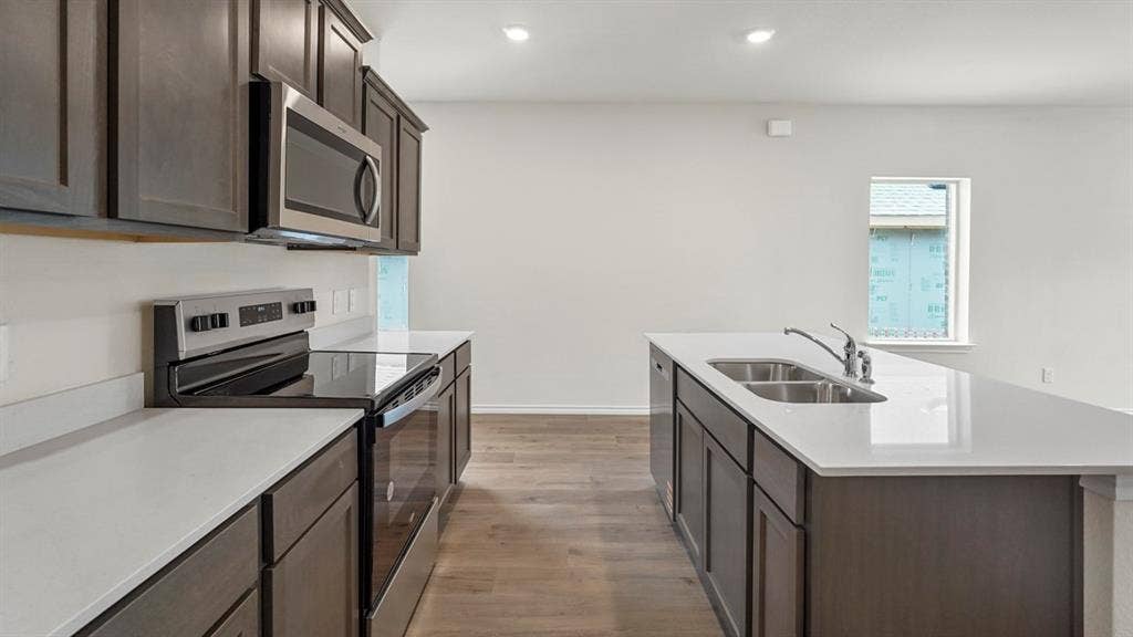 1619 Blaire Drive, Tyler, TX 75702 Contemporary kitchen featuring dark wood cabinetry, white countertops, stainless steel appliances, and wood-finish flooring