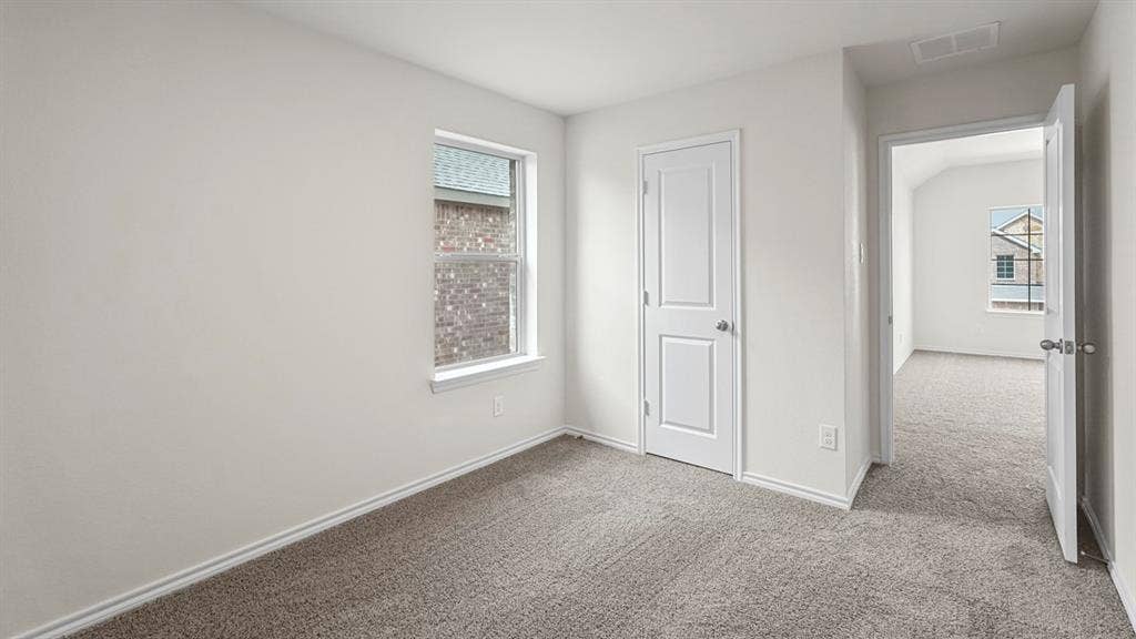 1619 Blaire Drive, Tyler, TX 75702 Carpeted interior room with white walls, white trim, a single window, and two paneled doors