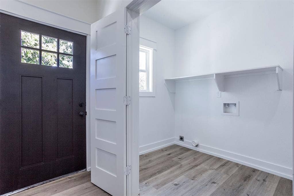 2608 Cleveland Avenue, Waco, TX 76711 Utility space featuring wood-finish flooring, white walls, and a built-in storage shelf