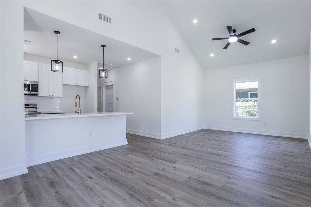 2608 Cleveland Avenue, Waco, TX 76711 Open-concept living space featuring wood-finish flooring, a vaulted ceiling, and recessed lighting