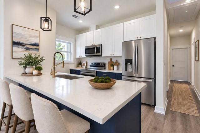 2608 Cleveland Avenue, Waco, TX 76711 Virtual staging - Kitchen featuring a white countertop island, stainless steel appliances, white upper cabinetry, and blue lower cabinetry