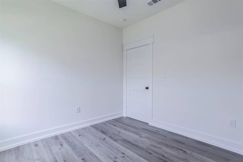 2608 Cleveland Avenue, Waco, TX 76711 Light-filled room featuring wood-finish flooring, white baseboards, and a contemporary flat-panel door with black hardware