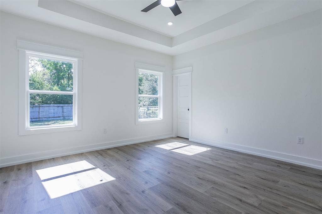 2608 Cleveland Avenue, Waco, TX 76711 Room with wood-finish flooring, white walls, and a tray ceiling