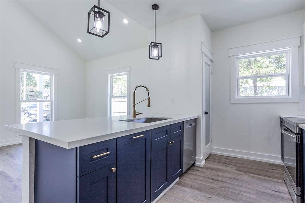 2608 Cleveland Avenue, Waco, TX 76711 Kitchen island with white countertop, dark blue cabinetry, and brass hardware