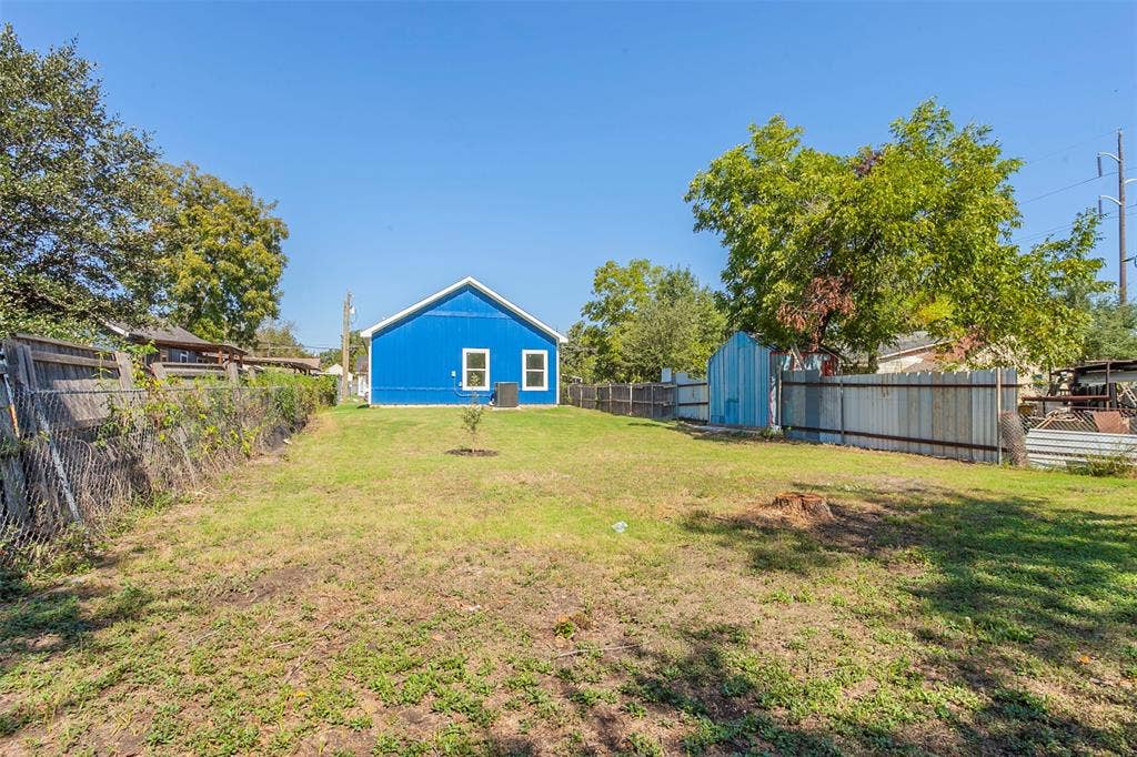 2608 Cleveland Avenue, Waco, TX 76711 Spacious backyard featuring a blue exterior dwelling, mature trees, and a combination of chain-link and privacy fencing