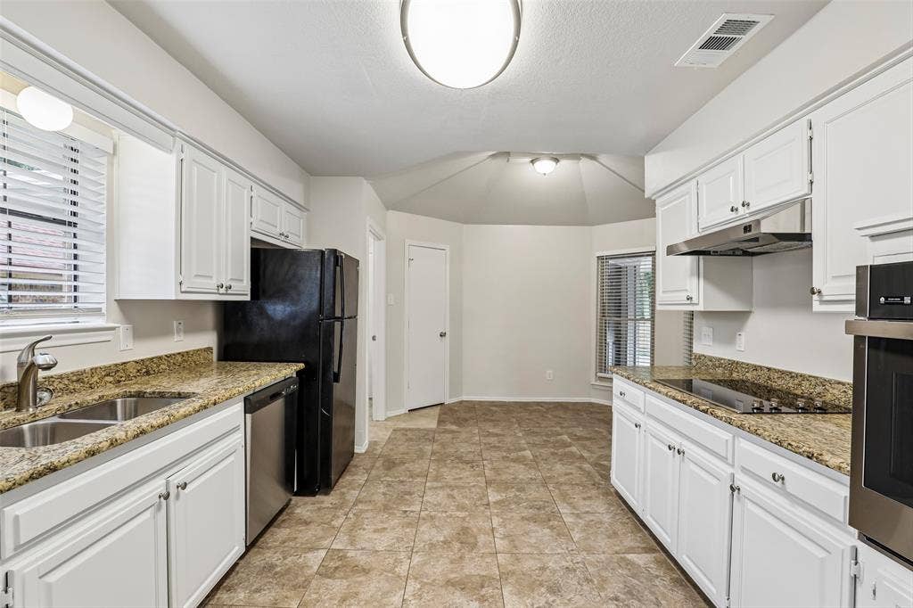612 E Oak Street, Wylie, TX 75098 Kitchen featuring white cabinetry, granite-style countertops, stainless steel sink, tile flooring, and integrated stainless steel appliances