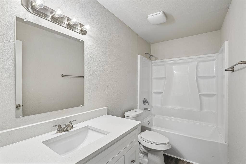 612 E Oak Street, Wylie, TX 75098 Bathroom featuring a white vanity with an integrated sink, brushed nickel faucet, and a large mirror