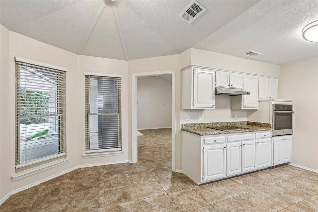 612 E Oak Street, Wylie, TX 75098 Kitchen featuring white cabinetry, a built-in oven, a stovetop, and granite-style countertops