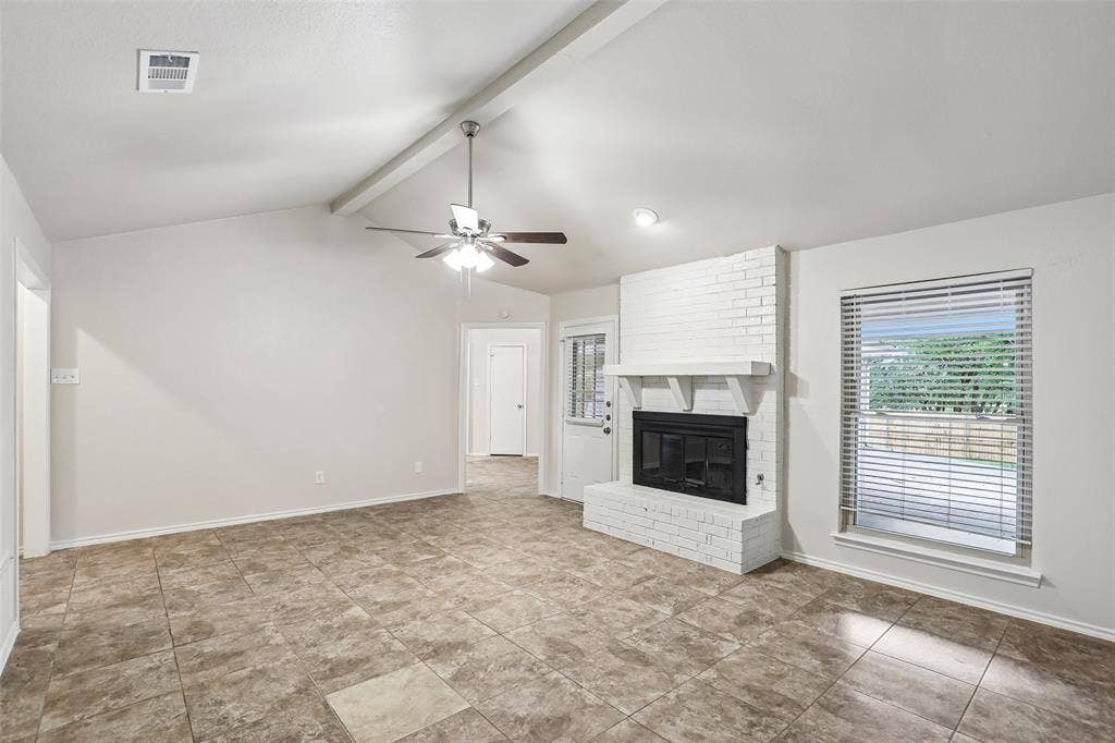 612 E Oak Street, Wylie, TX 75098 Spacious living area featuring vaulted ceilings, a white brick fireplace, and durable tile flooring