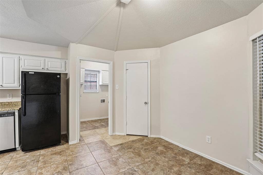 612 E Oak Street, Wylie, TX 75098 Kitchen area featuring white cabinetry, a black refrigerator, and a dishwasher