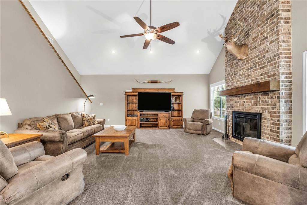 613 Bone Road, Valley Mills, TX 76689 Living room featuring a vaulted ceiling with recessed lighting, a ceiling fan, and a floor-to-ceiling brick fireplace with a wood mantle
