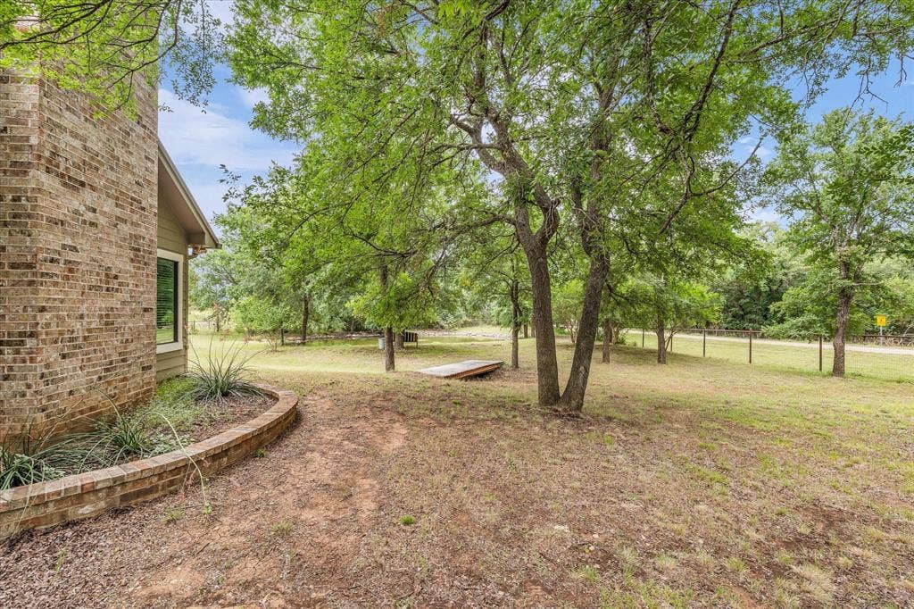 613 Bone Road, Valley Mills, TX 76689 Brick exterior with a window, surrounded by mature trees