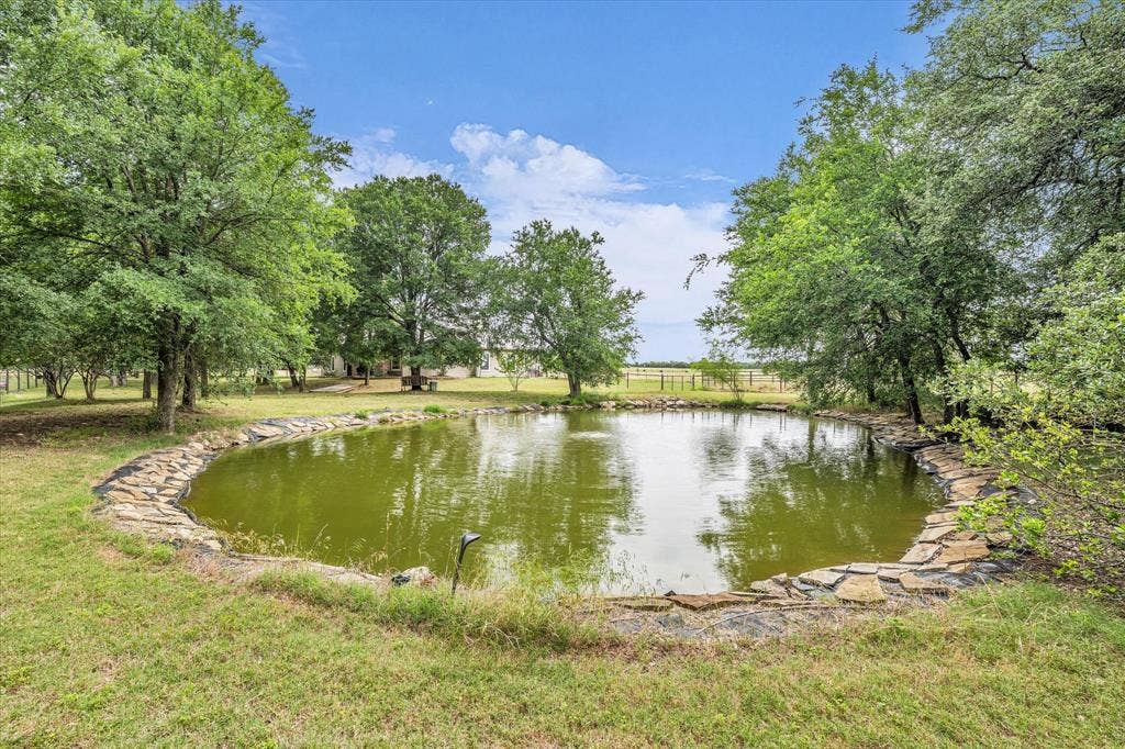 613 Bone Road, Valley Mills, TX 76689 Pond with a natural stone border and surrounding trees