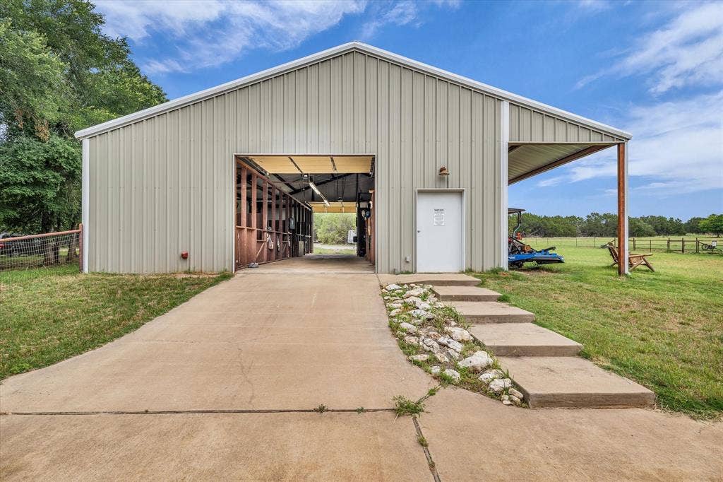 613 Bone Road, Valley Mills, TX 76689 Metal-sided barn featuring an open bay entrance, side entry door, and an attached covered overhang