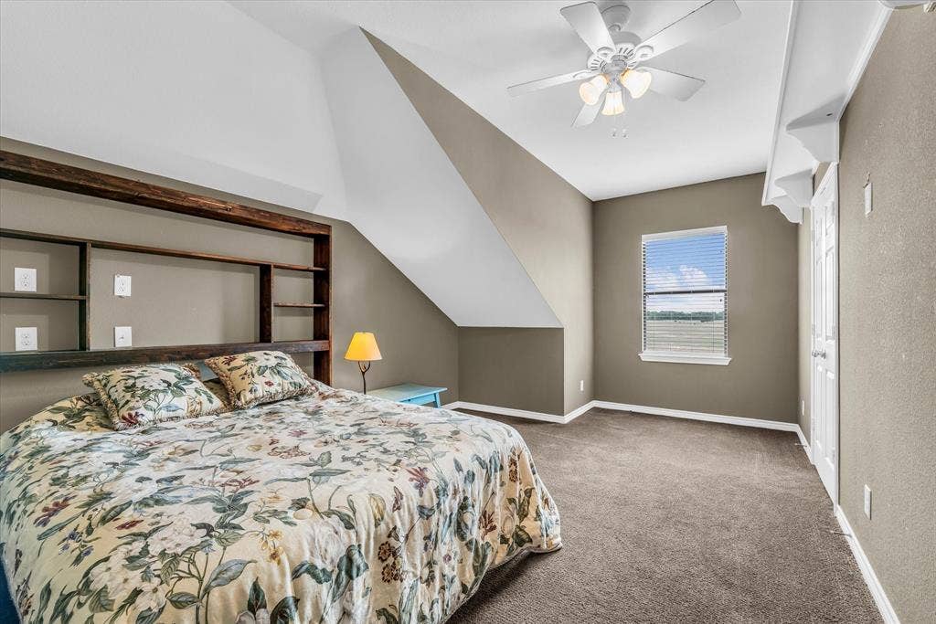 613 Bone Road, Valley Mills, TX 76689 Carpeted room featuring a built-in wooden headboard with shelving, a window with blinds, and a ceiling fan with integrated lighting