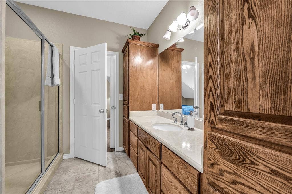 613 Bone Road, Valley Mills, TX 76689 Bathroom featuring a dual vanity with light-colored countertops, wood-finish cabinetry, and a framed mirror