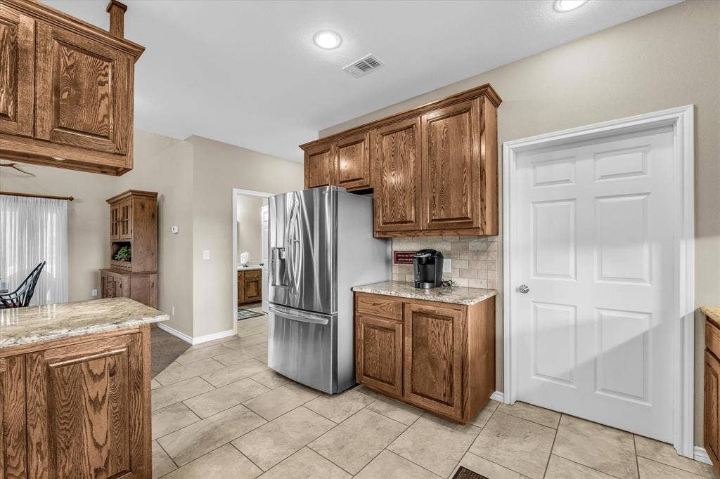 613 Bone Road, Valley Mills, TX 76689 Kitchen featuring extensive wood cabinetry, granite countertops, tile flooring, and recessed lighting
