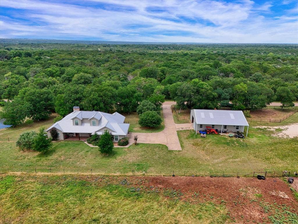 613 Bone Road, Valley Mills, TX 76689 Ranch-style residence featuring a prominent metal roof, a covered front porch, and a stone chimney