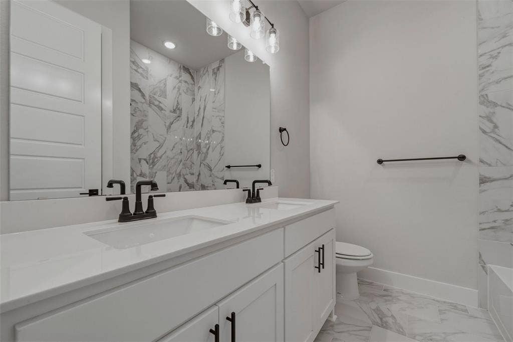 2305 Quartz Street, Krum, TX 76249 Dual vanity with integrated sinks, matte black fixtures, and white cabinetry