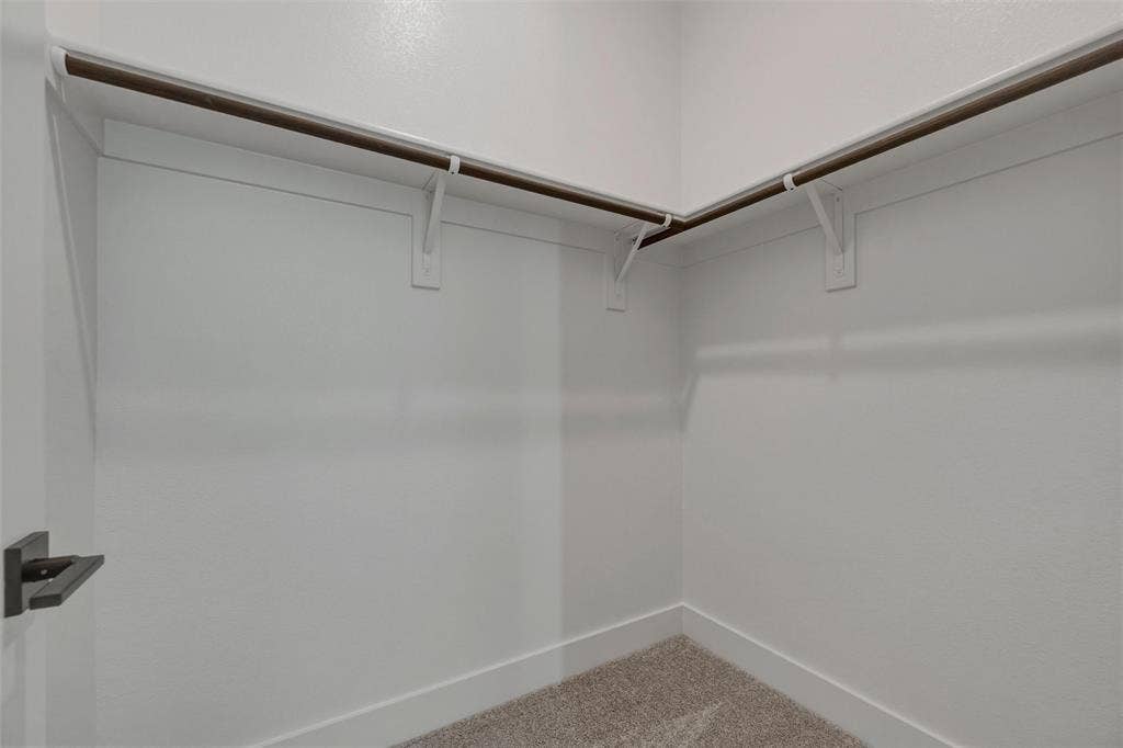 2305 Quartz Street, Krum, TX 76249 Walk-in closet with carpet flooring, white walls, and built-in shelving with hanging rods