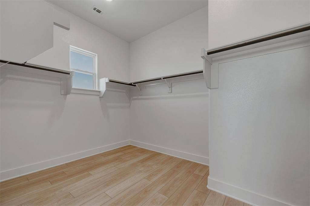 2305 Quartz Street, Krum, TX 76249 Expansive closet with wood-finish flooring, white walls, built-in shelving, and a prominent window