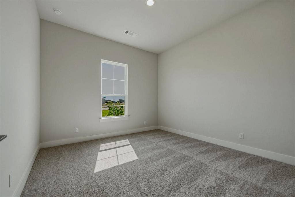 2305 Quartz Street, Krum, TX 76249 Neutral tone wall paint, vaulted ceiling, recessed lighting, carpet flooring, and a large window