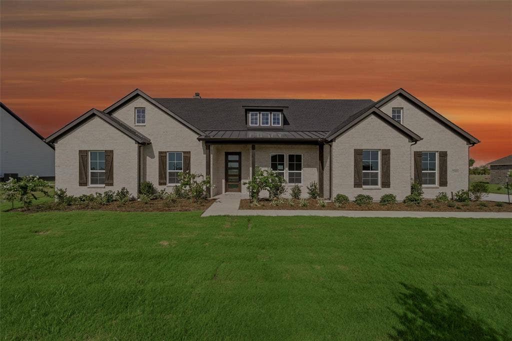 2305 Quartz Street, Krum, TX 76249 Light-colored brick exterior with dark roof, wood shutters, and front entryway with a dark door