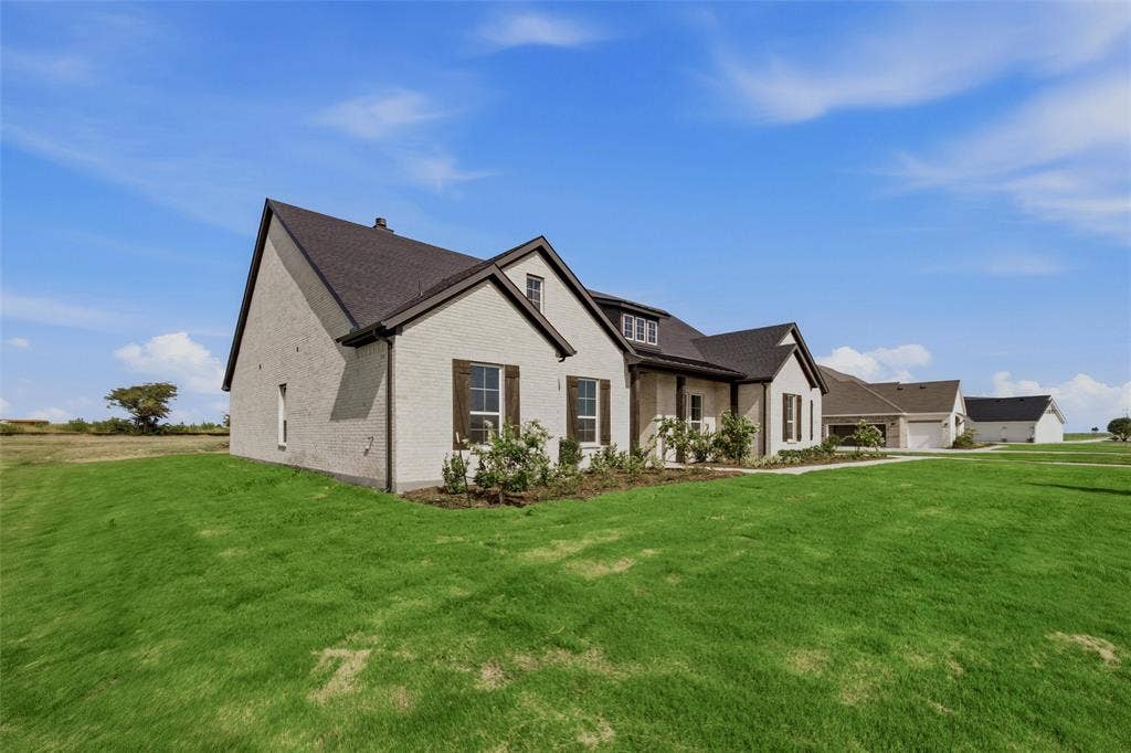 2305 Quartz Street, Krum, TX 76249 Two-story exterior with a light-colored facade, dark shingle roof, and dark window shutters
