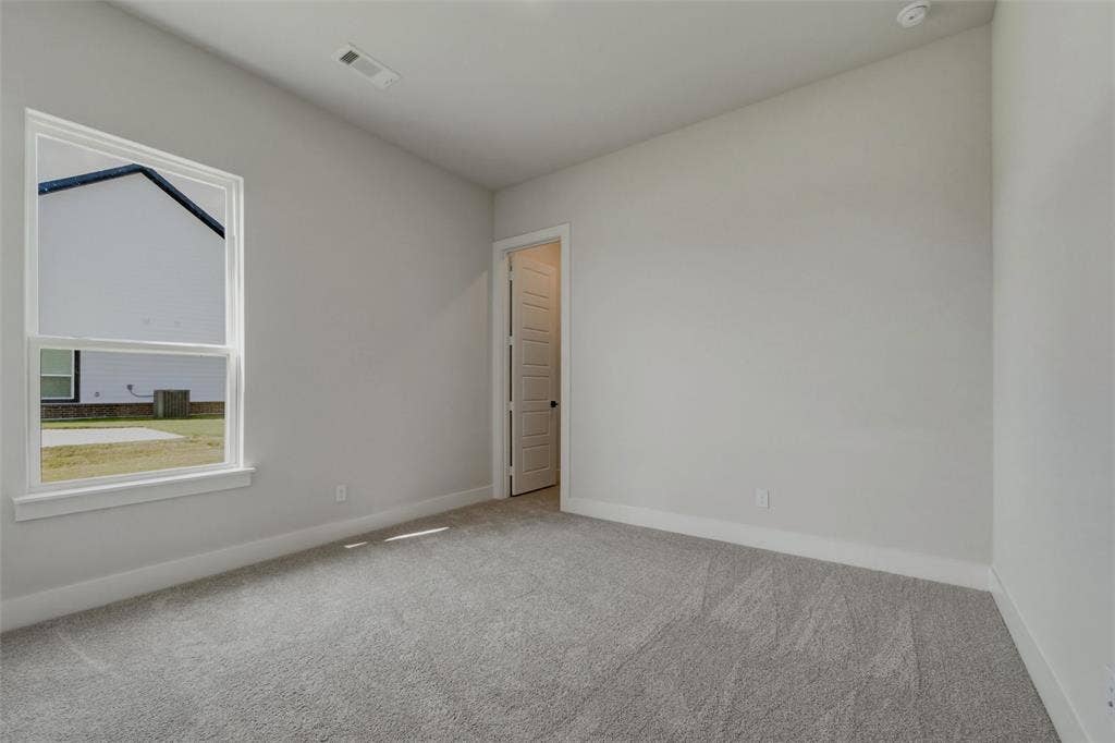 2305 Quartz Street, Krum, TX 76249 Light gray wall color, textured gray carpeting, white trim, recessed lighting, and a paneled door