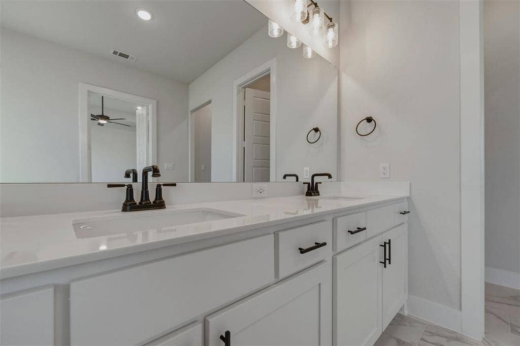 2305 Quartz Street, Krum, TX 76249 Dual sink vanity with white cabinetry, white countertops, and matte black fixtures